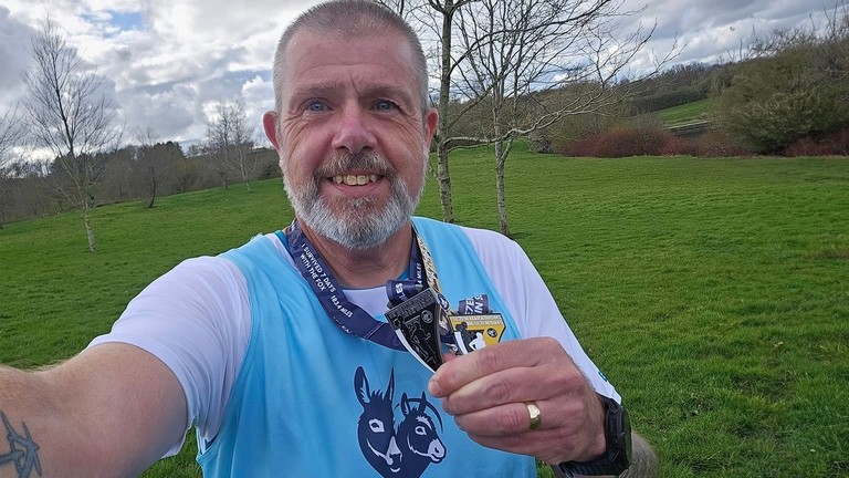 Clive Poole wearing a Donkey Sanctuary vest showing his medals