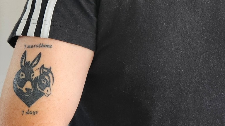 Clive Poole with Donkey Sanctuary tattoo on his arm