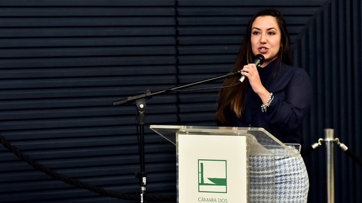 A women stood behind a podium speaking into a microphone