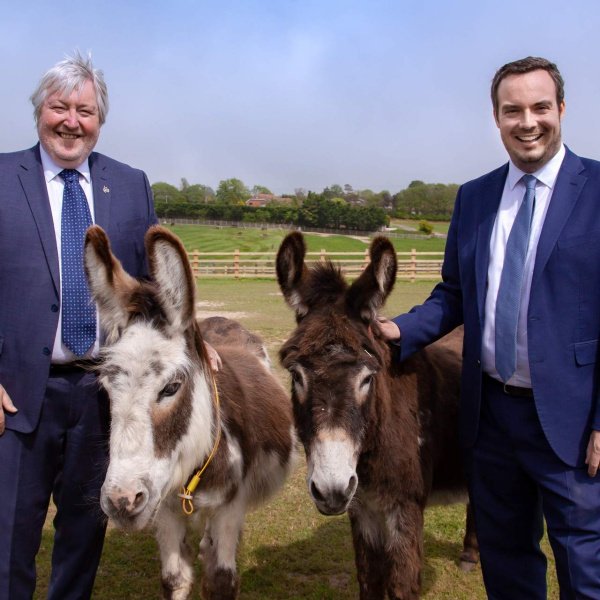 Simon Jupp, MP with Ian Cawsey, Director of Advocacy and Campaigns, standing with two donkeys