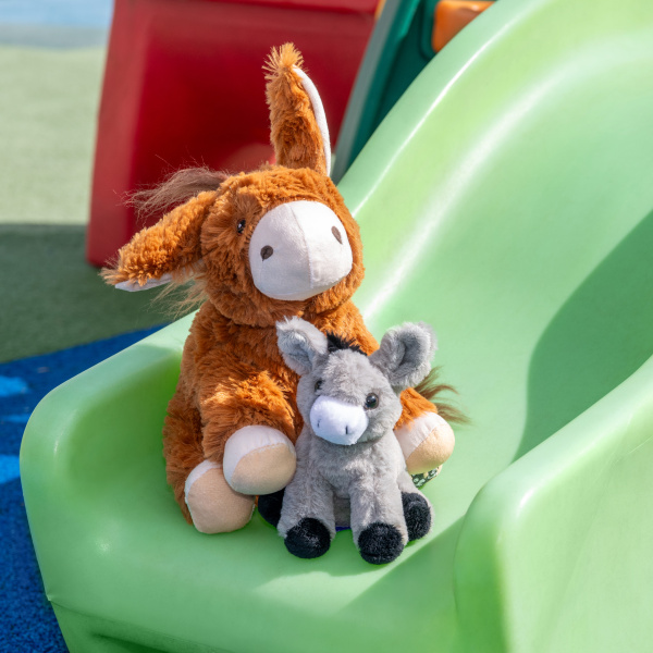 Two donkey soft toys on a slide.