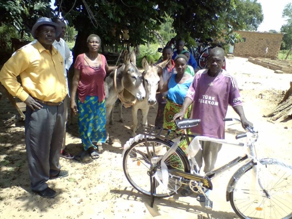 Villagers with donkeys and new funded bike in Zambia