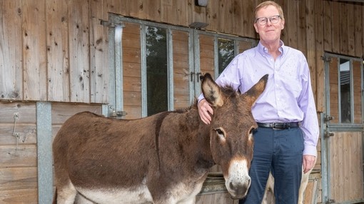 Photograph of Paul Lunn, Chair of Trustees, standing with a donkey.