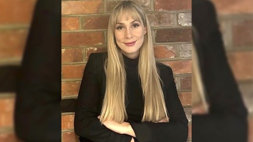 A headshot image of a blonde women with her arms crossed