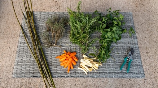 A placemat with wooden twigs, green leaves and vegetables and pillars