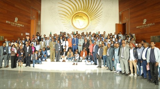 A large group of people looking toward camera whilst stood on a raise platform.