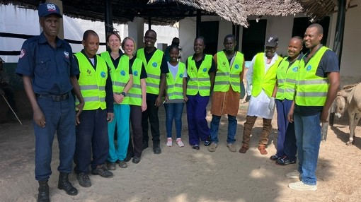 A group of men and women wearing hi-vis jackets smiling at the camera