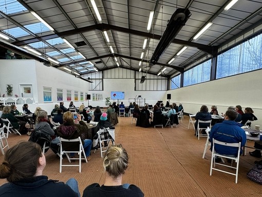 Attendees of the HETI forum in large room.
