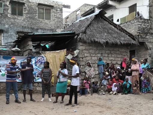 A group of six residents in Lamu performing forum theatre to a crowd of people