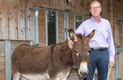 Photograph of Paul Lunn, Chair of Trustees, standing with a donkey